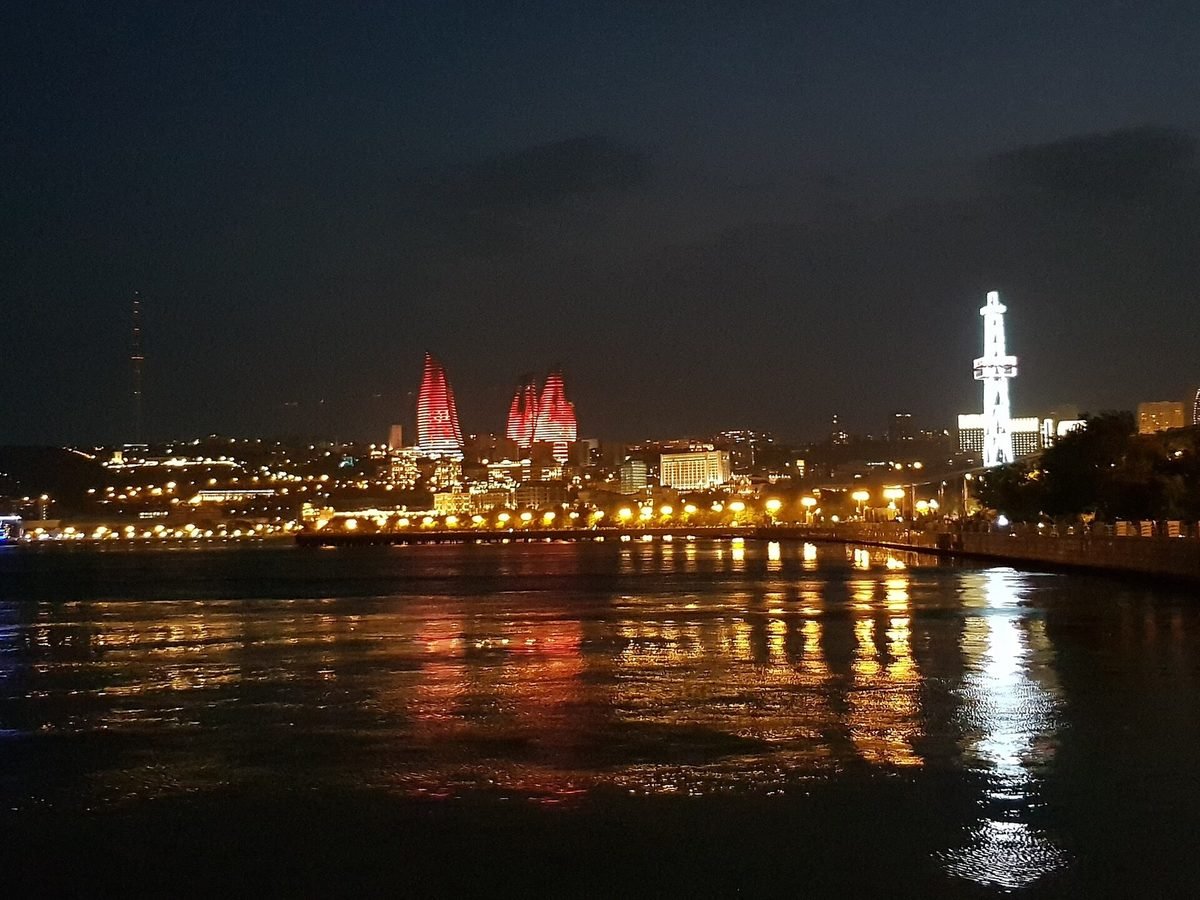 Baku's waterfront at night with the Flame Towers lit above the Caspian Sea