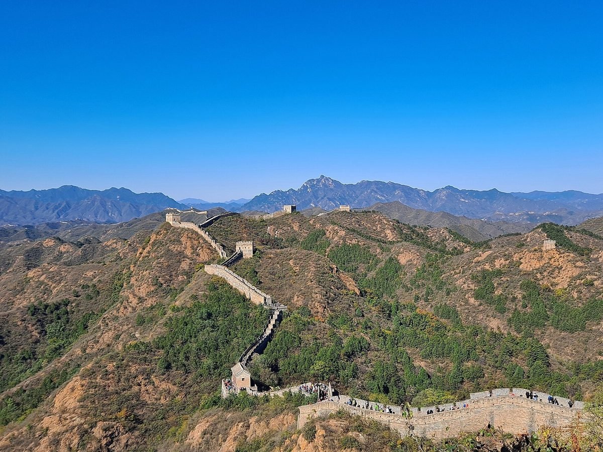 The Great Wall of China winding along green mountain ridges