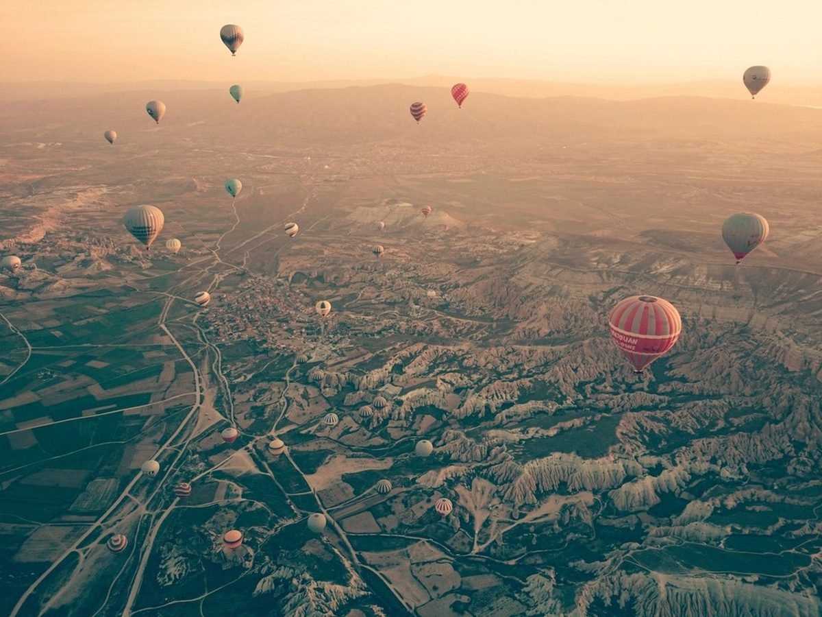 Hot-air balloons drifting over the Cappadocia valleys at sunrise
