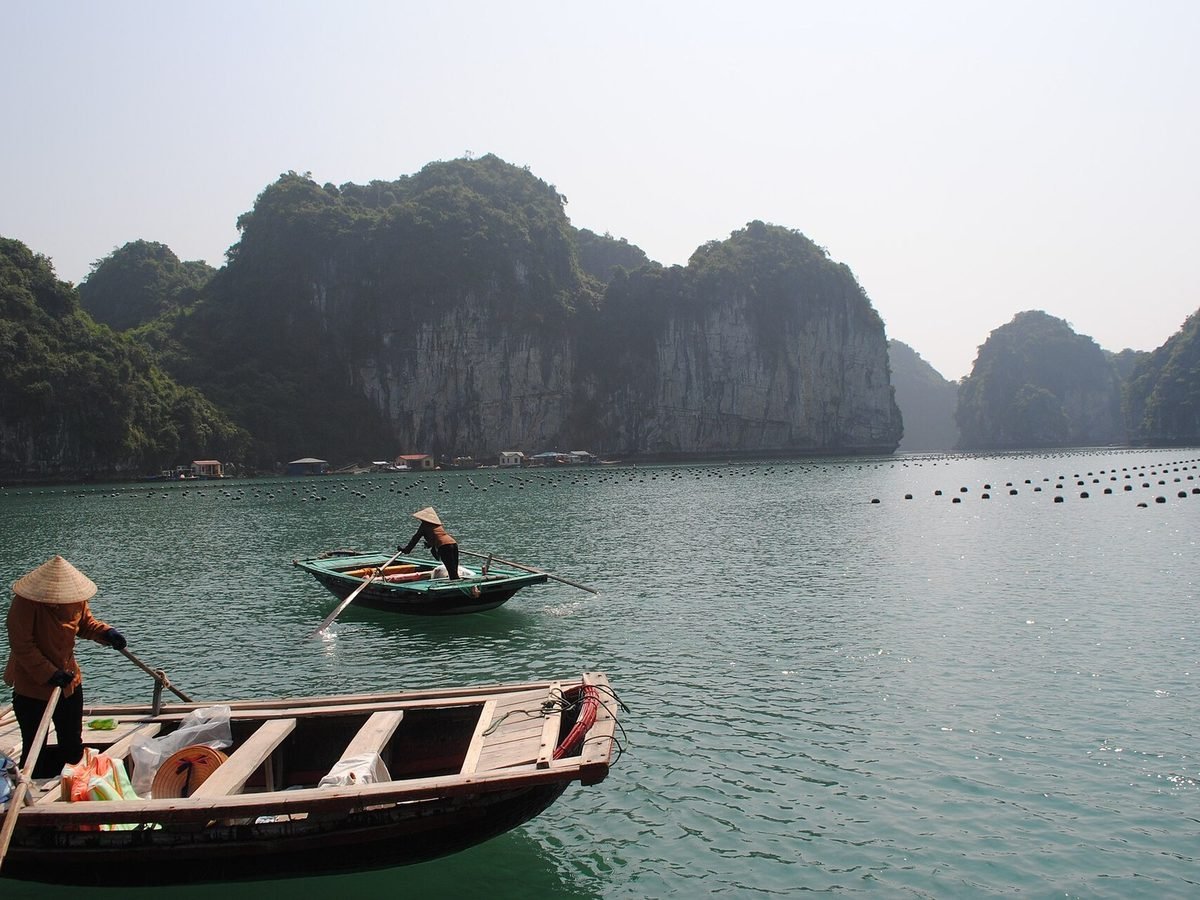A boat crossing Ha Long Bay between limestone karsts in Vietnam